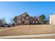 Two-story brick home featuring a manicured lawn, symmetrical windows, and a black front door at 104 Lumby Ln, Stockbridge, GA 30281