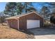 Detached brick garage with a white garage door and driveway at 104 Lumby Ln, Stockbridge, GA 30281