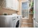 Bright laundry room features a washer and dryer with storage shelves and a window for natural light at 104 Lumby Ln, Stockbridge, GA 30281