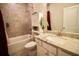 Cozy bathroom featuring a tub with tile surround, granite countertop sink, and stylish decor at 166 Fender Walk, Marietta, GA 30060