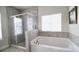 Modern bathroom featuring a separate glass shower and soaking tub with gray tile at 166 Fender Walk, Marietta, GA 30060