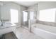 Bright bathroom with a glass shower, soaking tub, double sinks, and ceramic tile flooring at 166 Fender Walk, Marietta, GA 30060