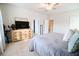 Bright bedroom with a dresser, TV, ceiling fan, and a comfortable bed covered by a soft gray blanket at 166 Fender Walk, Marietta, GA 30060