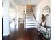 Bright foyer features dark wood floors, white stairs, and a console table with decorative round mirror at 166 Fender Walk, Marietta, GA 30060
