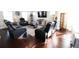 Open concept living room showcases dark wood flooring, and an array of comfortable black leather furniture at 166 Fender Walk, Marietta, GA 30060