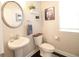 Charming powder room features a pedestal sink, decorative mirror, and modern décor at 166 Fender Walk, Marietta, GA 30060