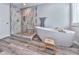 This stunning bathroom features a soaking tub, shower, and wood-look flooring and neutral tones at 305 Nobleman Way, Canton, GA 30114