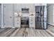 Kitchen with stainless steel appliances, white cabinetry, and wood-look flooring at 305 Nobleman Way, Canton, GA 30114
