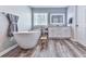 This stunning main bathroom features a soaking tub, double vanity, large mirror and wood-look flooring at 305 Nobleman Way, Canton, GA 30114