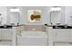 Bright bathroom featuring dual sinks, black countertops, and a soaking tub at 3621 Vinings Slope Se # 3204, Atlanta, GA 30339