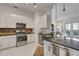 Modern kitchen with stainless steel appliances, granite countertops, and access to the living room at 3621 Vinings Slope Se # 3204, Atlanta, GA 30339