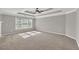 Expansive main bedroom with tray ceiling, carpet flooring, and natural light from the large window at 3634 Lost Oak Dr, Buford, GA 30519