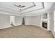 Spacious bedroom with tray ceilings, fireplace, and adjacent bathroom at 3634 Lost Oak Dr, Buford, GA 30519
