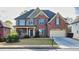 Charming two-story brick home with inviting front porch and manicured lawn at 3634 Lost Oak Dr, Buford, GA 30519