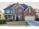 Charming two-story brick home featuring a manicured lawn and attached two car garage at 3634 Lost Oak Dr, Buford, GA 30519