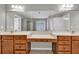 Bright bathroom featuring a double vanity with wood cabinets, large mirrors, and neutral countertops at 3634 Lost Oak Drive, Buford, GA 30519