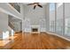 Open-concept living room features hardwood floors, a fireplace with built-in shelves, and lots of windows at 3634 Lost Oak Drive, Buford, GA 30519