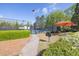 Well-maintained tennis court with lighting, covered seating, and lush landscaping at 3634 Lost Oak Drive, Buford, GA 30519
