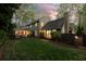 View of a verdant backyard with mature landscaping and an attached screened in porch at 540 Cambridge Way, Atlanta, GA 30328
