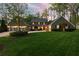 Stunning two-story home with a well-manicured lawn, lush landscaping, and a circular driveway at dusk at 540 Cambridge Way, Atlanta, GA 30328