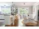 Bright kitchen and breakfast nook with hardwood floors, white cabinetry, granite countertops and sunroom access at 540 Cambridge Way, Atlanta, GA 30328