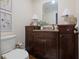 Charming powder room with dark wood cabinets, granite countertop, and elegant decor at 540 Cambridge Way, Atlanta, GA 30328
