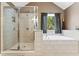 Bright bathroom features a glass enclosed shower, soaking tub, and a window view at 150 Fitzroy Ln, Acworth, GA 30101