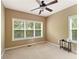 Bedroom with neutral walls, a ceiling fan, and two bright windows with wooded views at 150 Fitzroy Ln, Acworth, GA 30101