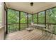 Relaxing screened porch with wooden floors, ceiling light, and serene views of the surrounding trees at 150 Fitzroy Ln, Acworth, GA 30101