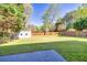 Expansive backyard with lush green grass, a shed, and a sturdy wooden fence providing privacy at 210 Chandler Ct, Sugar Hill, GA 30518