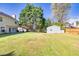Spacious backyard with a storage shed and mature trees, complemented by a well-maintained lawn and back patio at 210 Chandler Ct, Sugar Hill, GA 30518