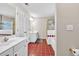Well-lit bathroom features red tiled floors, dual sinks and separate areas for both showering and bathing at 210 Chandler Ct, Sugar Hill, GA 30518