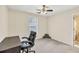 Inviting bedroom features a ceiling fan, a window providing natural light and a desk with an office chair at 210 Chandler Ct, Sugar Hill, GA 30518