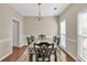Formal dining room featuring wood floors, chandelier lighting, chair rail molding, and natural light from windows at 210 Chandler Ct, Sugar Hill, GA 30518