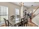Spacious dining room with chandelier, dark wood table, and windows providing ample natural light at 210 Chandler Ct, Sugar Hill, GA 30518