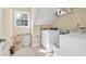 Functional laundry room equipped with a washer, dryer, storage shelves, and natural light from the window at 210 Chandler Ct, Sugar Hill, GA 30518