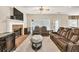 Relaxing living room with fireplace, hardwood floors, and a plush brown sectional sofa, perfect for entertaining at 210 Chandler Ct, Sugar Hill, GA 30518