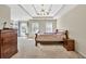 Spacious main bedroom featuring tray ceilings, a ceiling fan, and built-in shelving with many decorative items at 210 Chandler Ct, Sugar Hill, GA 30518