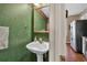 Half bath with pedestal sink and ornate green wallpaper at 210 Chandler Ct, Sugar Hill, GA 30518
