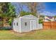 View of the backyard shed showing ample storage space with double doors and small windows in a grassy yard at 210 Chandler Ct, Sugar Hill, GA 30518
