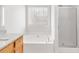 Bright bathroom features a soaking tub under a window and a glass-enclosed shower at 7806 Poppy Seed Pl, Winston, GA 30187