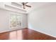 Bedroom with wood floors, neutral walls, tray ceiling, and large window at 7806 Poppy Seed Pl, Winston, GA 30187
