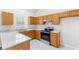 Bright kitchen featuring modern appliances, ample granite counter space, and natural wood cabinets at 7806 Poppy Seed Pl, Winston, GA 30187