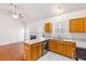 Open kitchen features wood cabinets, stainless steel appliances, and view of a living room at 7806 Poppy Seed Pl, Winston, GA 30187