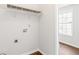 Bright laundry room with hardwood floors, a window, and utility connections at 7806 Poppy Seed Pl, Winston, GA 30187