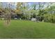 Backyard with expansive green lawn, mature trees, well, and a storage shed at 225 Valley Dr, Roswell, GA 30075