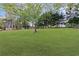 Expansive backyard featuring a lush green lawn and mature trees, offering privacy and ample space for outdoor activities at 225 Valley Dr, Roswell, GA 30075