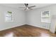 Spacious bedroom featuring hardwood floors, two windows, and a ceiling fan at 225 Valley Dr, Roswell, GA 30075
