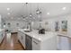 A large kitchen island has a sink with gooseneck faucet and space for bar stools in this open-concept space at 225 Valley Dr, Roswell, GA 30075