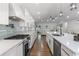 Bright, open kitchen with stainless steel appliances, gas range, and a large island with pendant lighting at 225 Valley Dr, Roswell, GA 30075